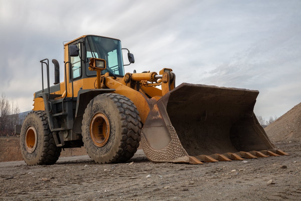 Industrial backhoe excavating for a driveway entrance