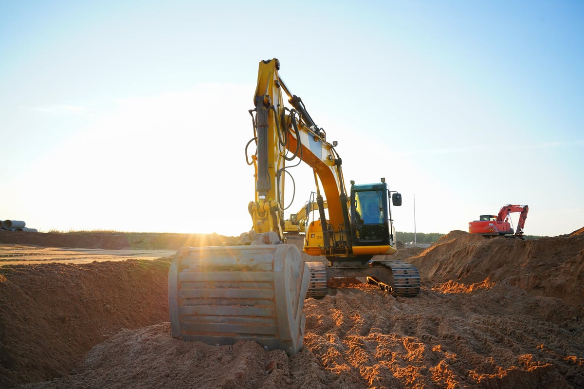 Excavator earthworks machinery digging a trench for water line repair